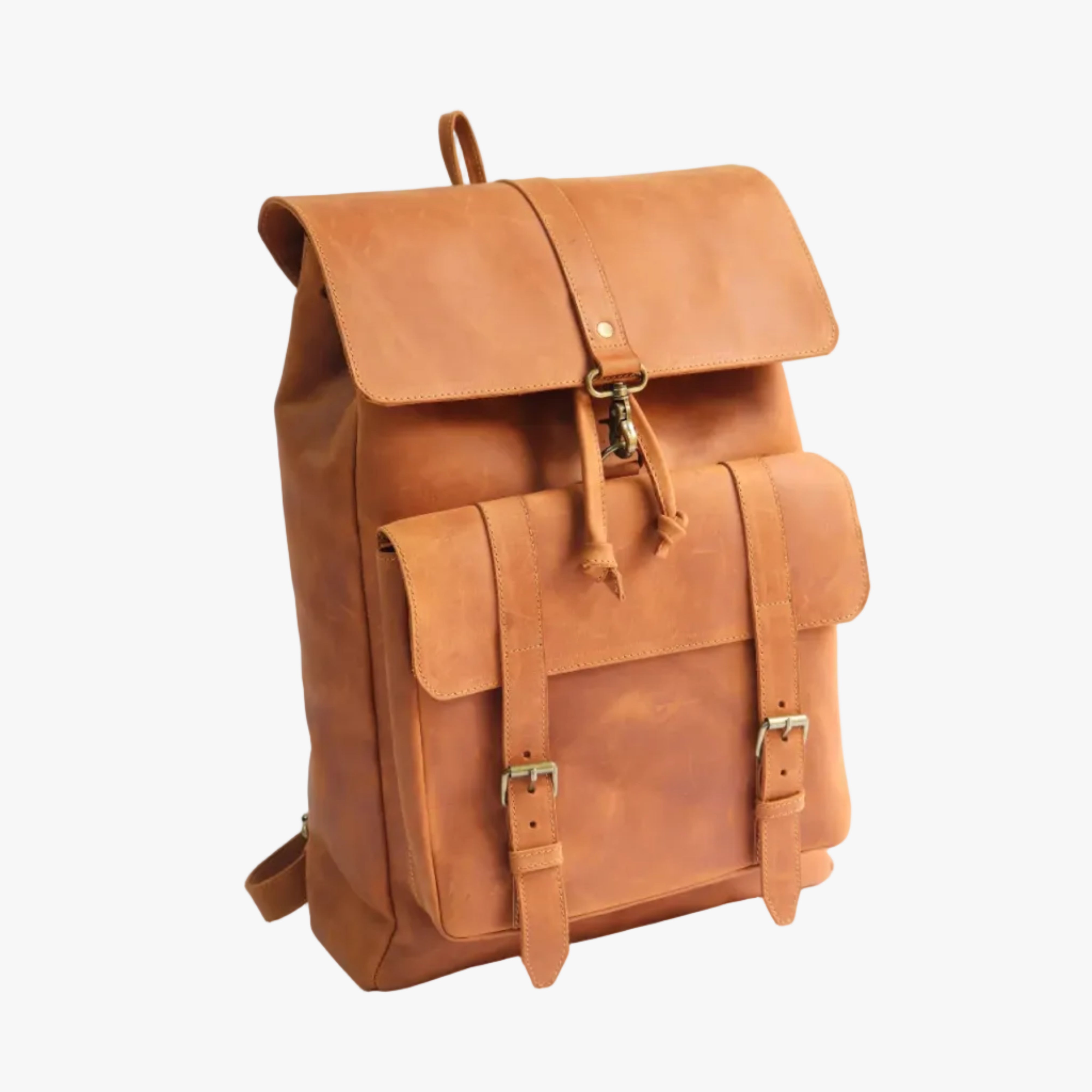 A tan leather backpack with a front flap pocket, buckle straps, and brass-tone hardware, photographed on a clean white studio background.