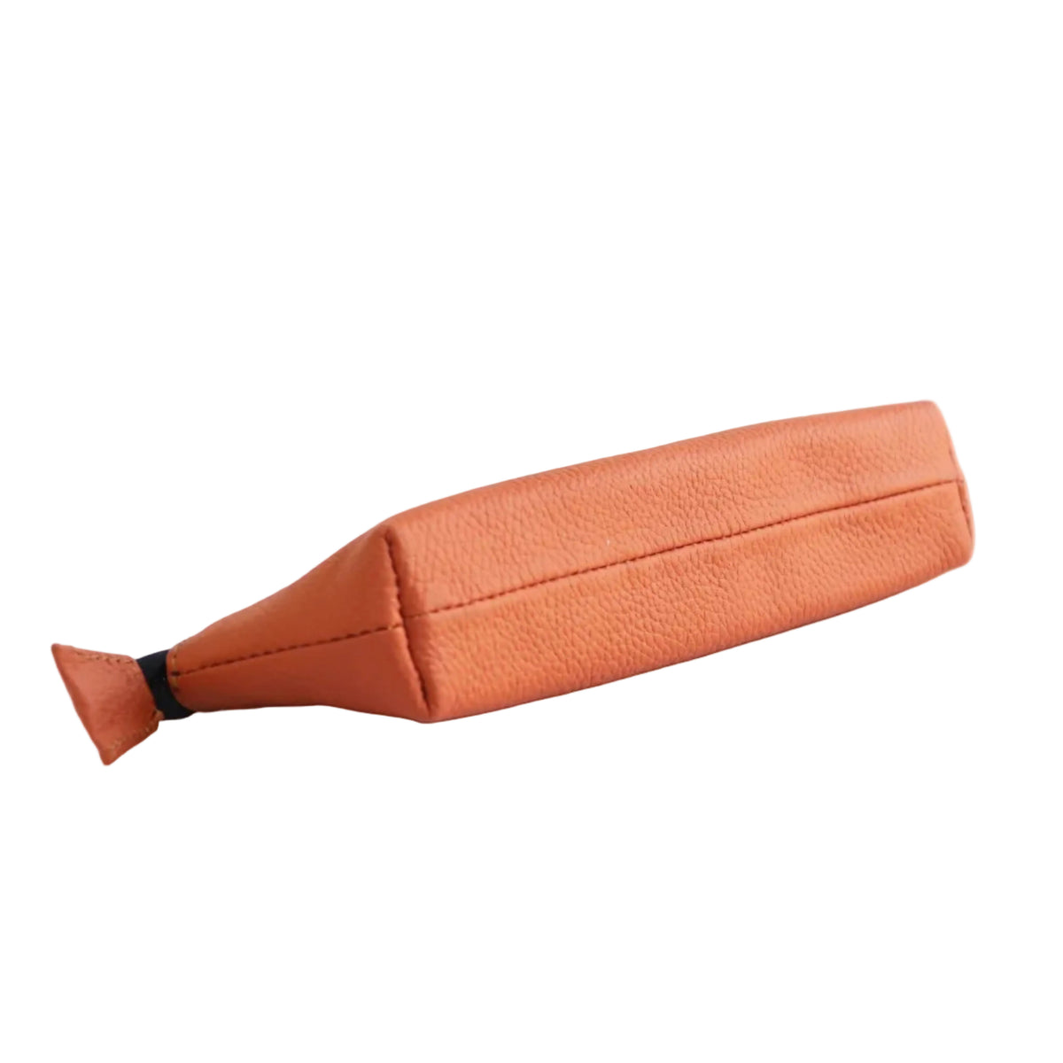 An orange textured faux-leather pouch with a tapered, bottle-like shape and a small black accent tab at the pointed end, shown on a solid pale pink background.