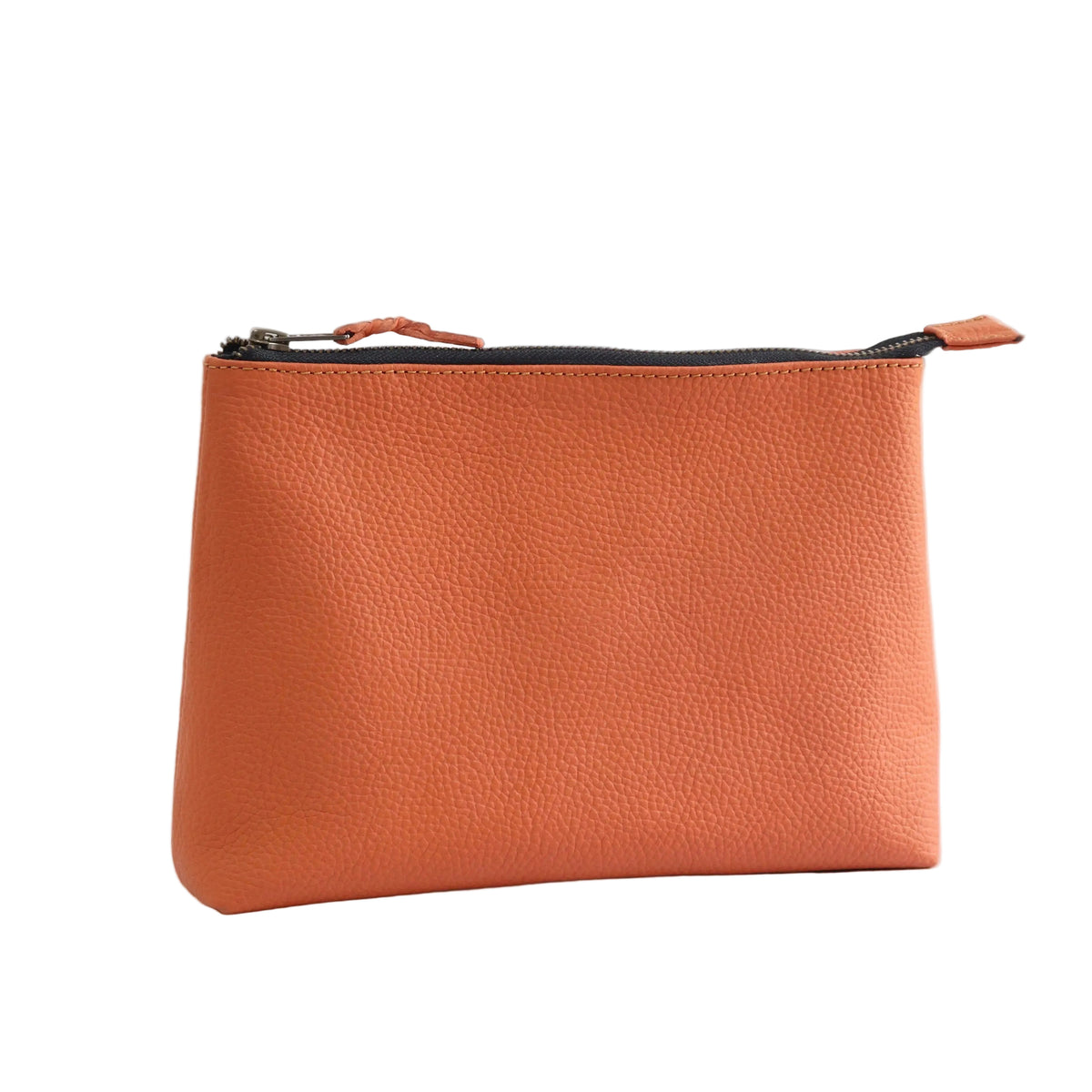 A small pebbled leather pouch in a warm terracotta orange color, featuring a black zipper with matching orange pull tabs, set against a plain white background.