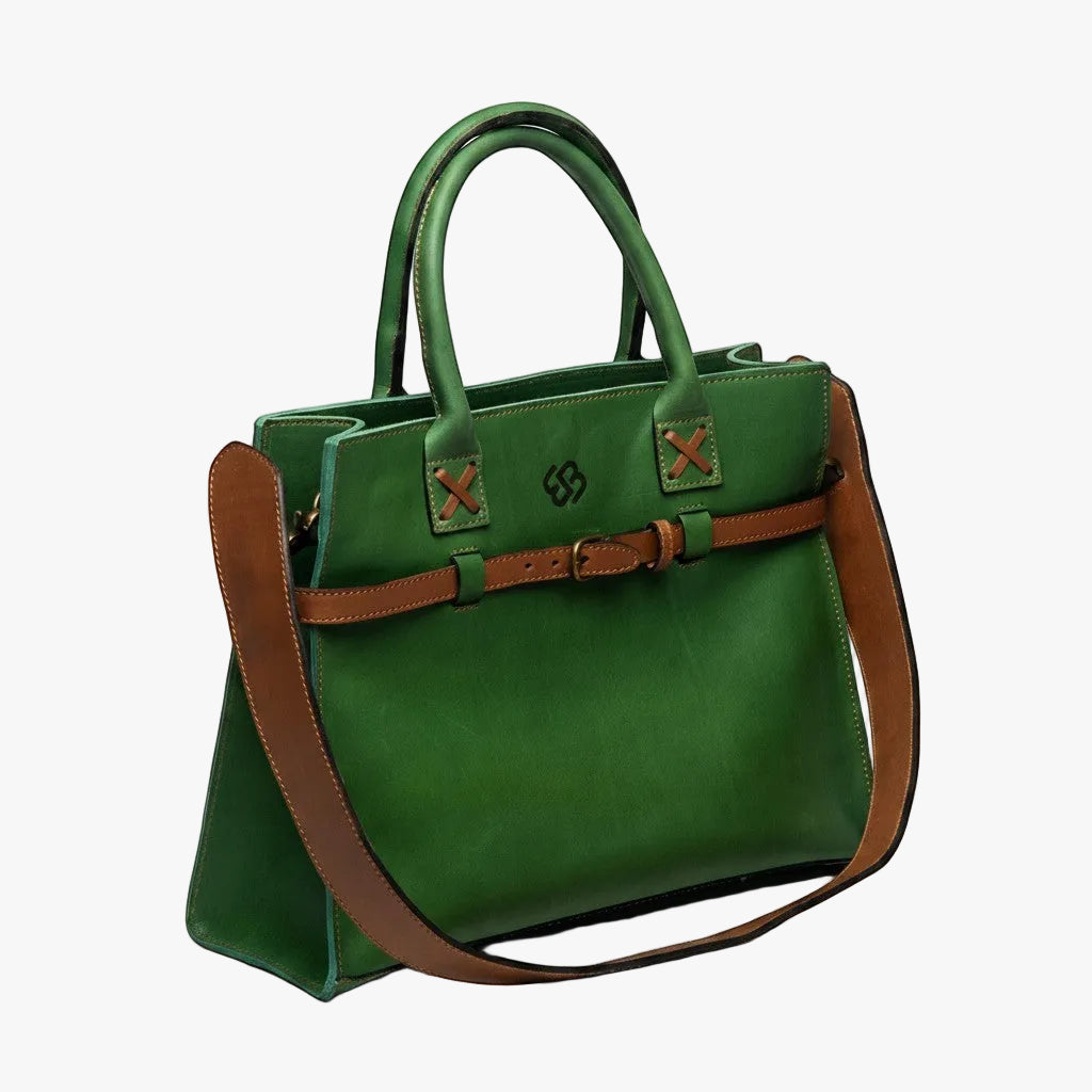 Blueberry Leather Duma Tote in forest green cowhide leather with a brown adjustable buckle strap and top handles.