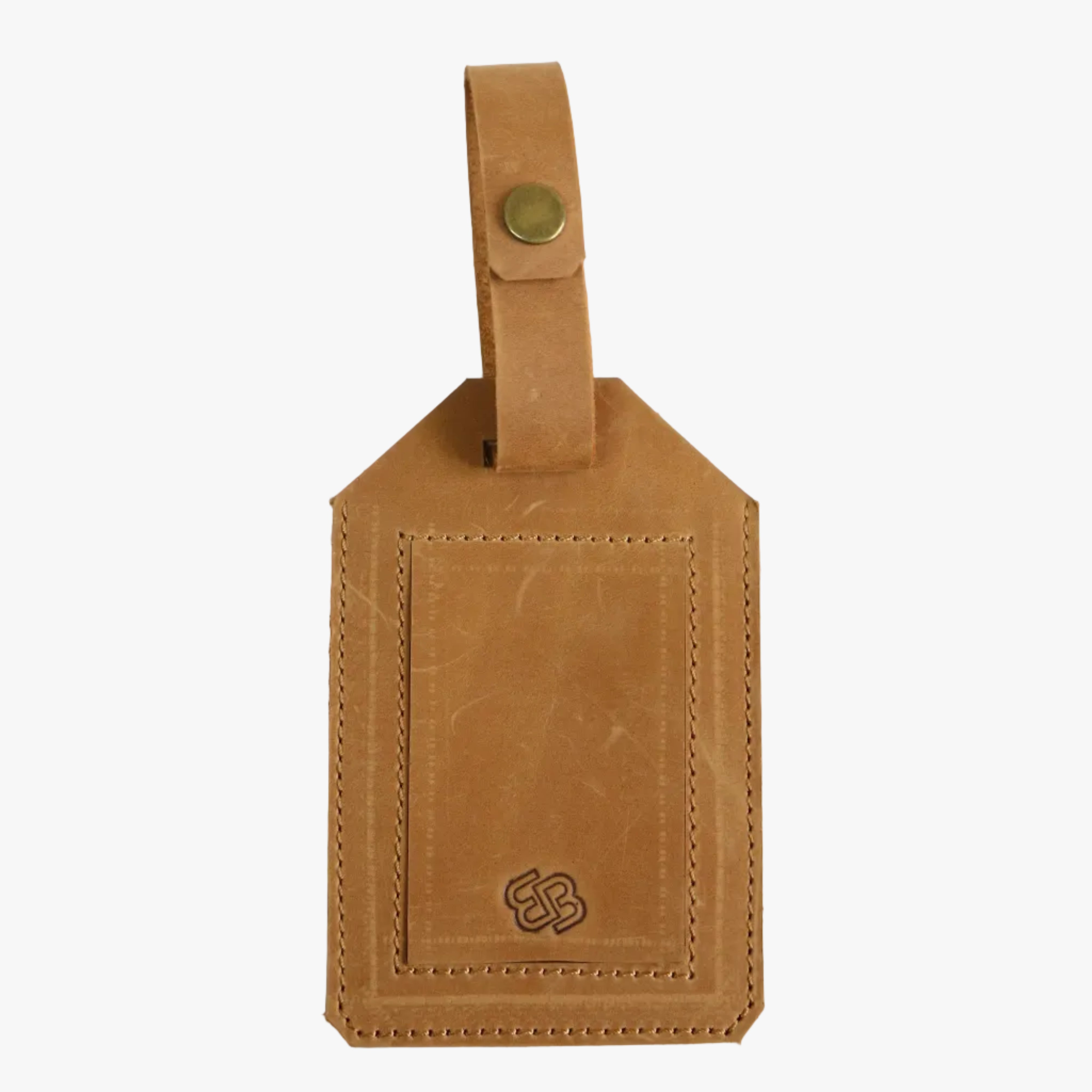 A tan leather luggage tag with a stitched border, a top loop secured by a brass snap, and an embossed logo near the bottom, displayed against a textured off-white background.