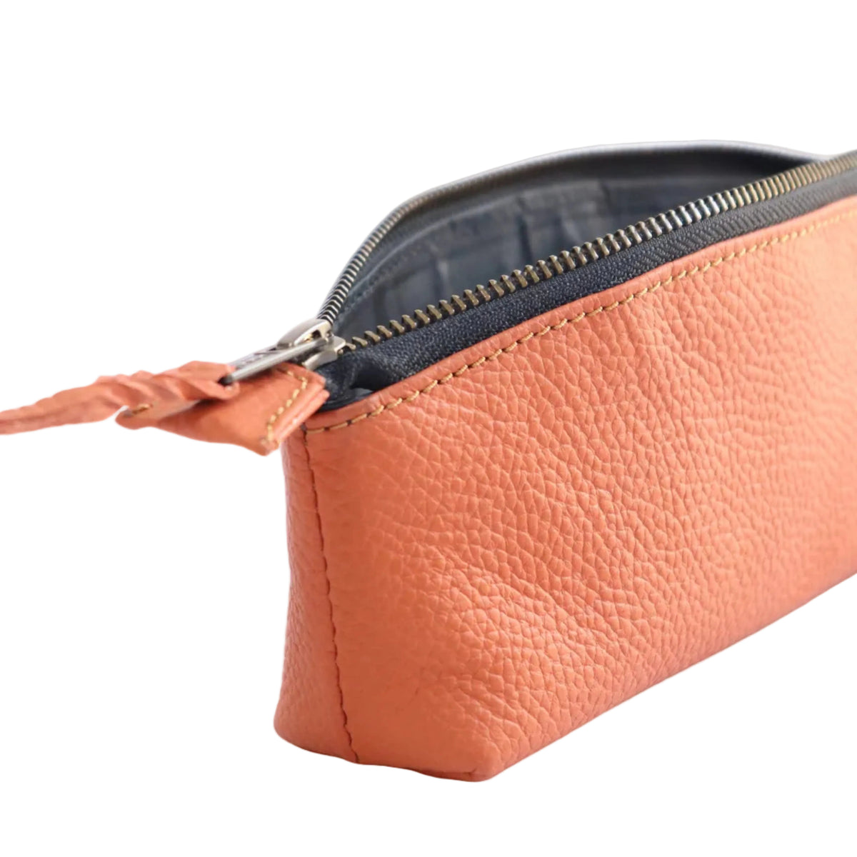 A close-up of a peach-colored pebbled leather pouch with a silver zipper and a matching leather pull tab, shown against a light beige background.