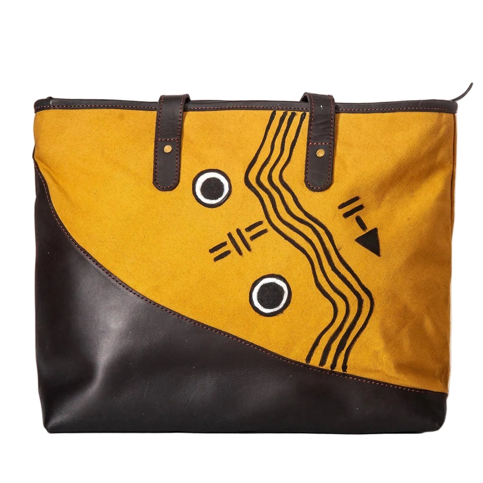A tote bag with a mustard yellow and black color-blocked design, featuring black leather handles and a black geometric line-art pattern on the yellow panel, set against a plain white background.