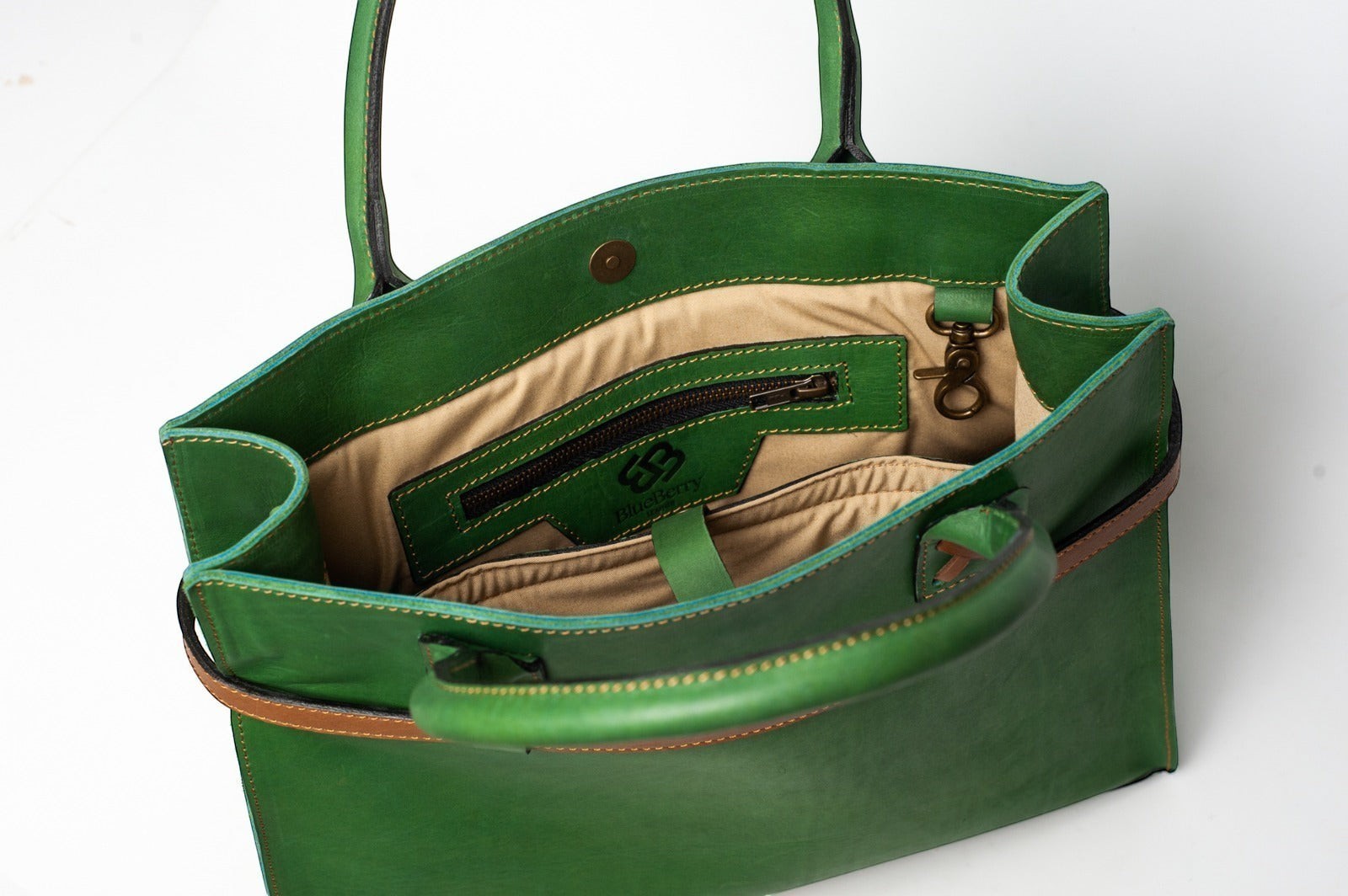 Blueberry Leather Duma Tote in forest green cowhide leather with interior snap button closure and beige lining.