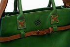 Blueberry Leather Duma tote in forest green cowhide leather with tan buckle strap and cross-stitched handle detail.